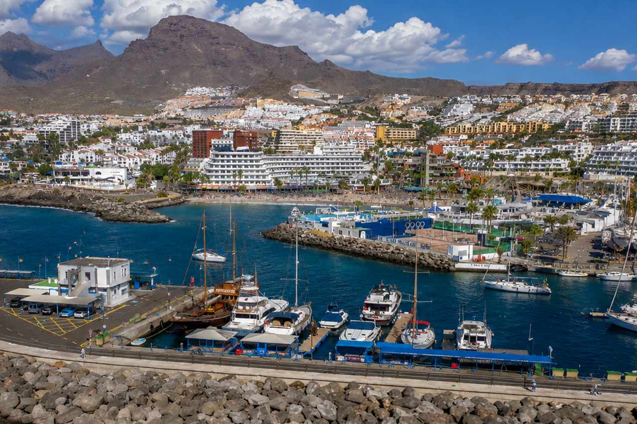 Panoramic view of Los Cristianos harbour in southern Tenerife, with yachts, marina facilities, the waterfront resort and Tenerife’s volcanic mountains in the background. Los Cristianos is the departure point for ferries travelling from Tenerife to La Gomera and is where guests can meet before beginning a La Gomera day trip