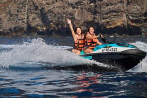 Ein Paar genießt eine Jet-Ski-Fahrt in der Nähe der Los Gigantes-Klippen bei einer geführten Jet-Ski-Tour auf Teneriffa