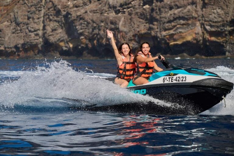 Cuplu care se bucură de o plimbare cu jet ski în apropierea stâncilor Los Gigantes în timpul unei excursii cu jet ski ghidate în Tenerife