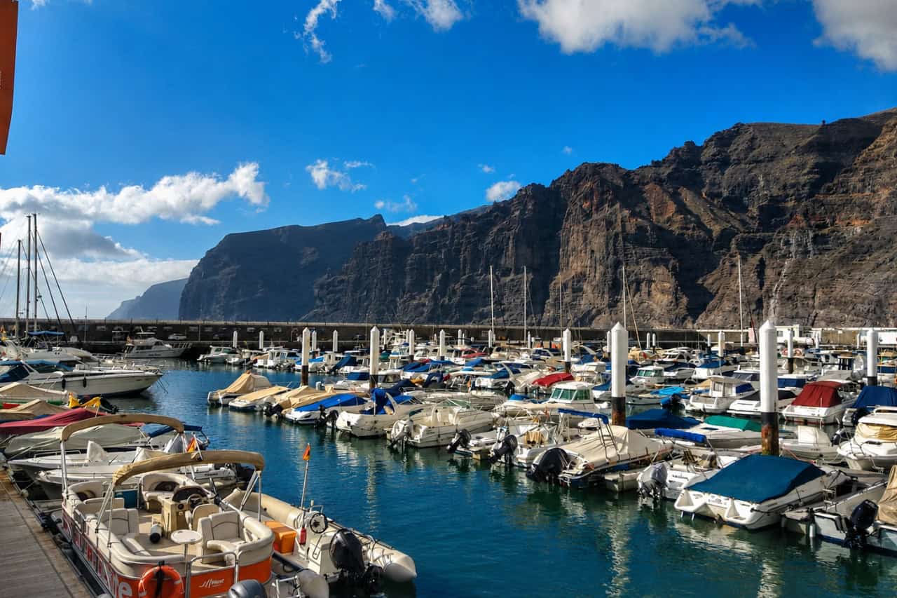 Los Gigantes marina filled with boats beneath the impressive volcanic cliffs of Tenerife.