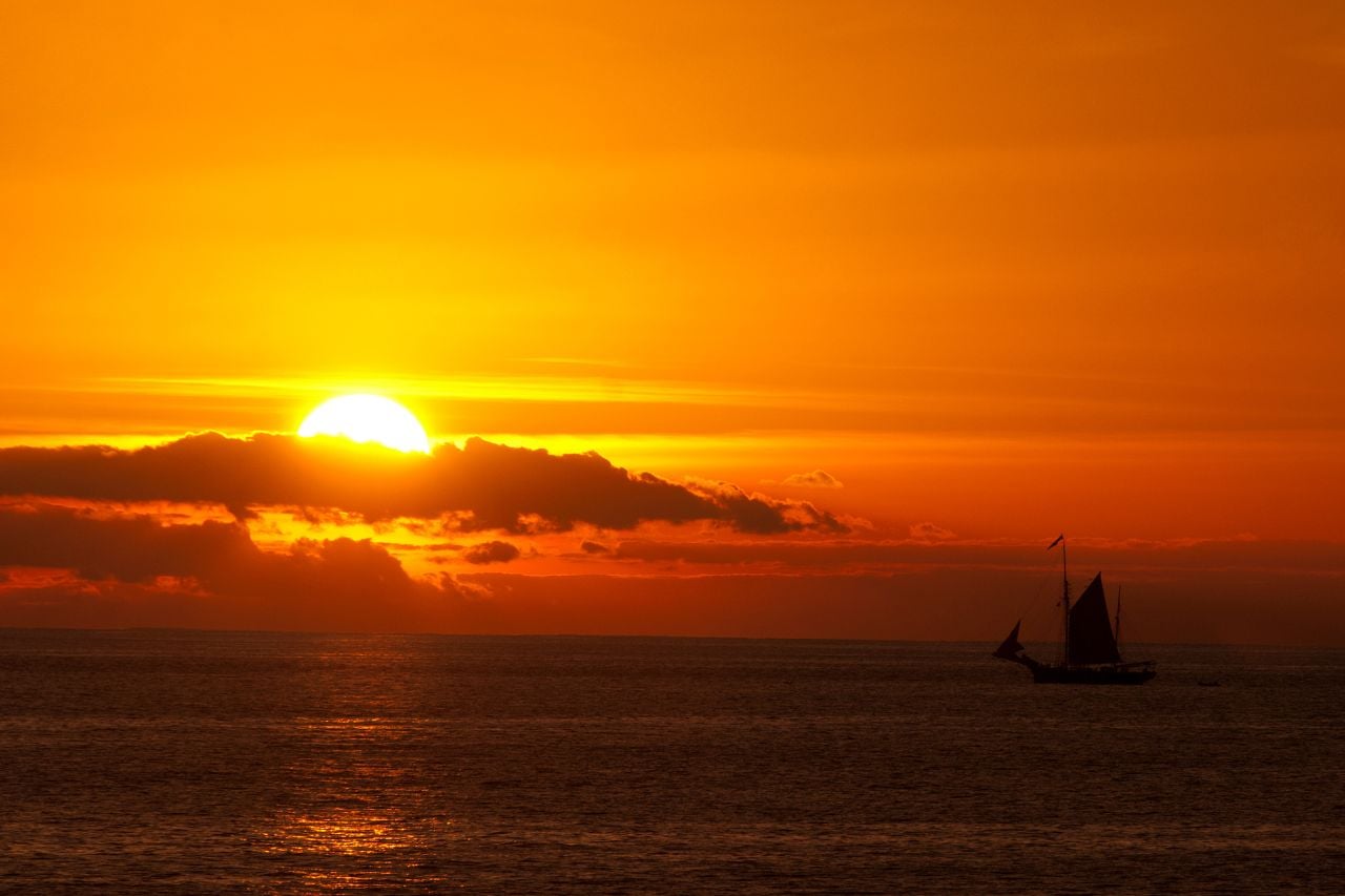 Sailing boat silhouetted against the golden Tenerife sunset