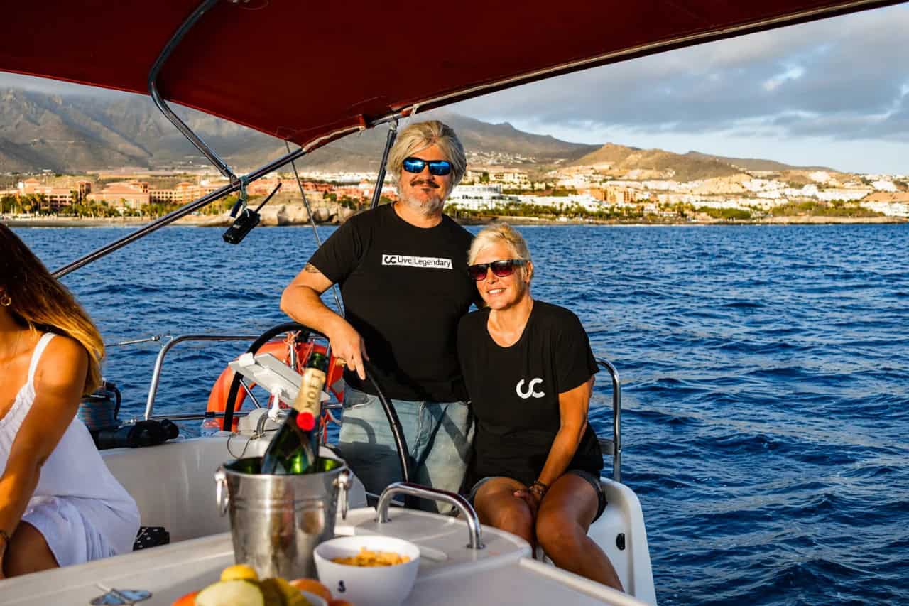 La tripulación del Club Canary a bordo con champán y la costa de Tenerife al fondo.