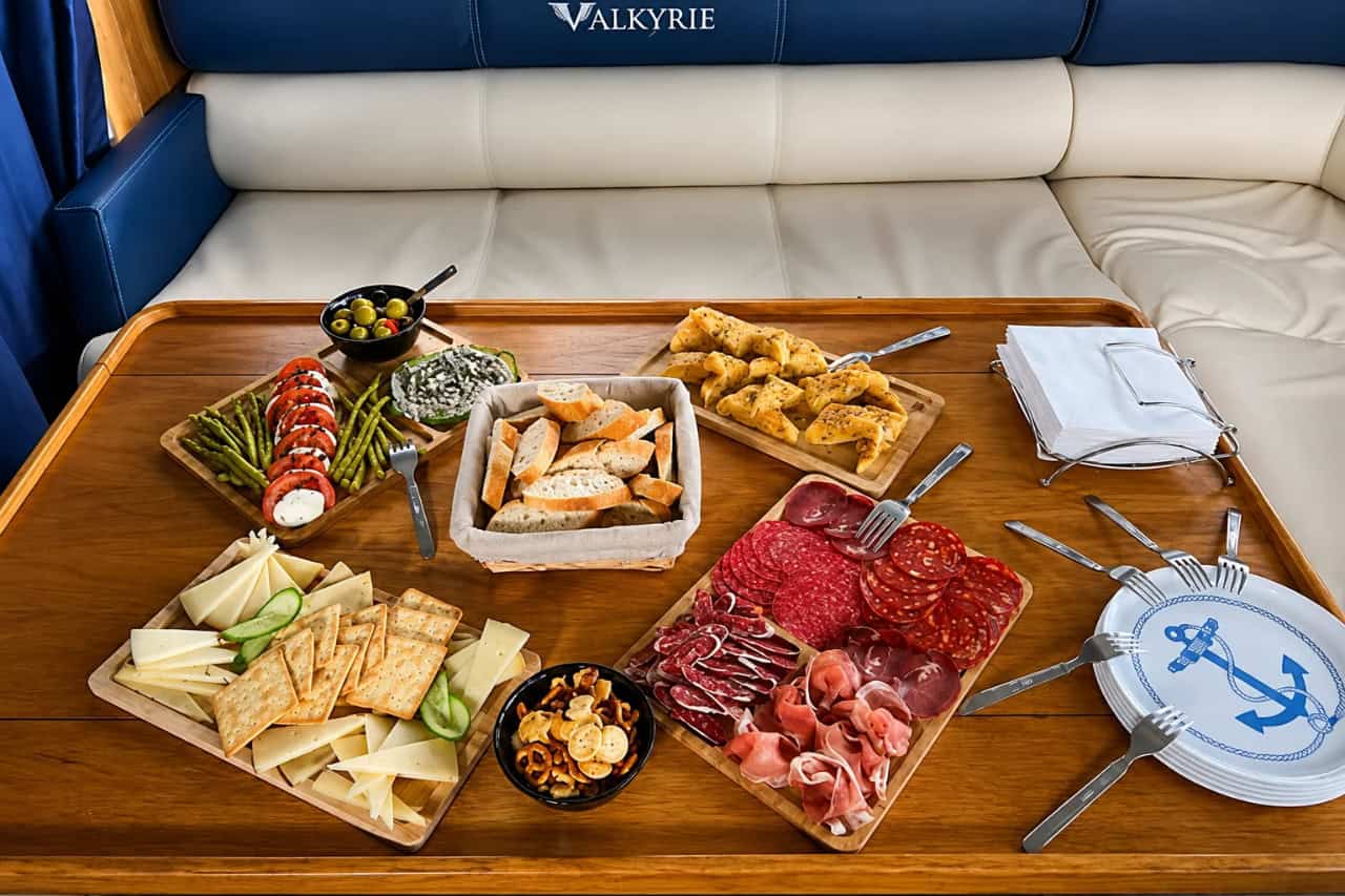Selección de aperitivos y embutidos servidos a bordo durante un viaje privado al atardecer