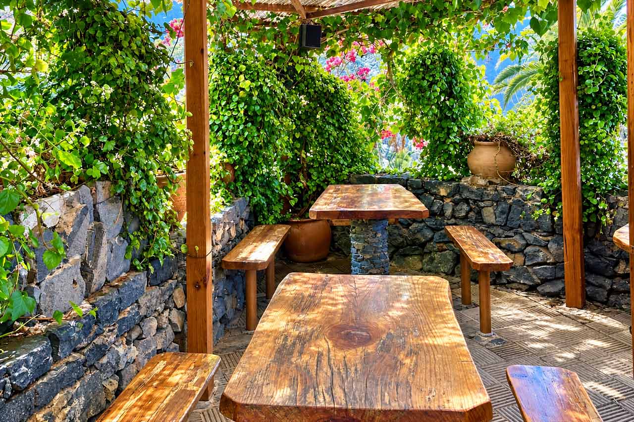 A shaded Canarian-style terrace representing the relaxed lunch break in Icod de los Vinos, where tour guests have free time to choose where and what they would like to eat.