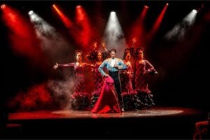 Bailarines del Olé Flamenco Show actuando en el escenario bajo luces rojas dramáticas en Tenerife