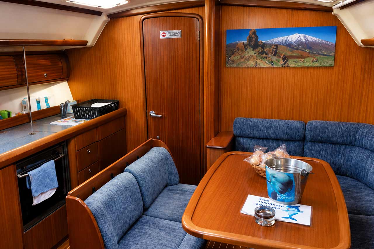Interieurloounge van het Skyline zeiljacht met comfortabele zitplaatsen, houten afwerking en een eethoek binnen