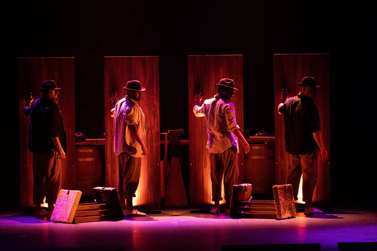 Vier artiesten voor verlichte houten panelen tijdens de show