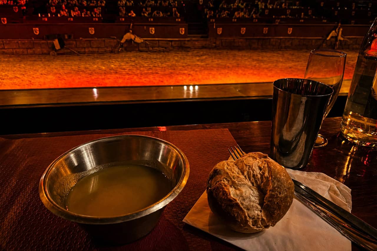 Bowl of soup and a bread roll served beside the arena during the medieval banquet Tenerife experience.