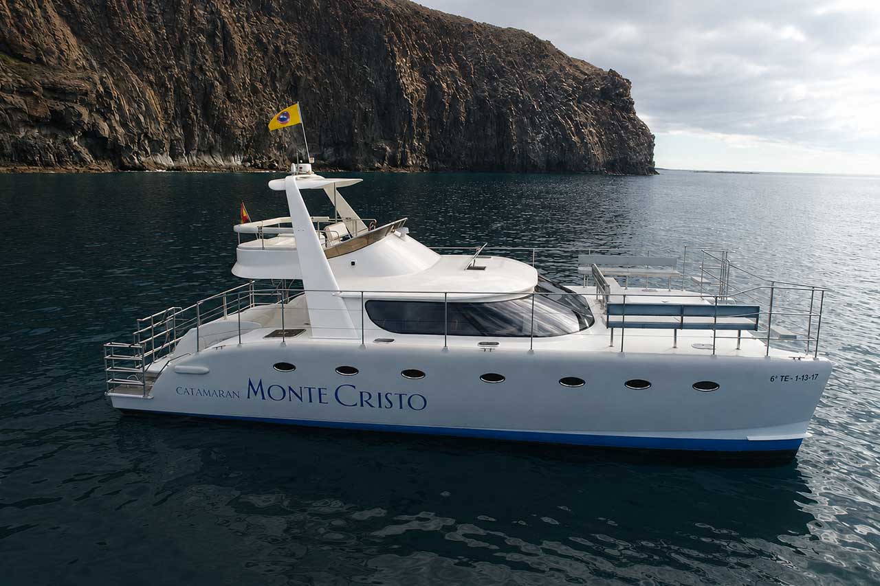 Le catamaran Monte Cristo est ancré au large de la spectaculaire côte volcanique de Ténérife, dans les eaux calmes de l'Atlantique.