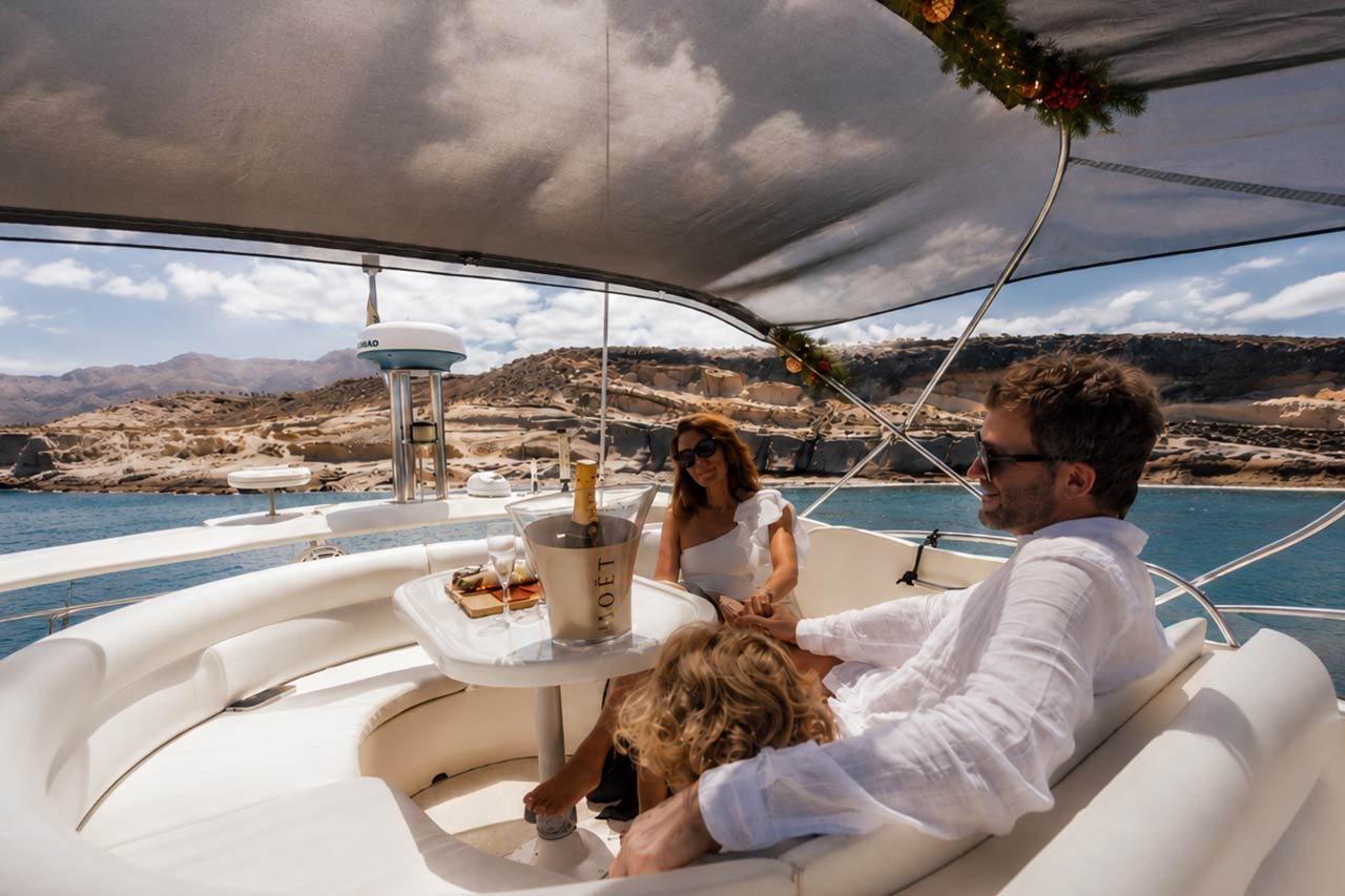 A family relaxing with drinks aboard the Seaduction yacht off the Tenerife coast