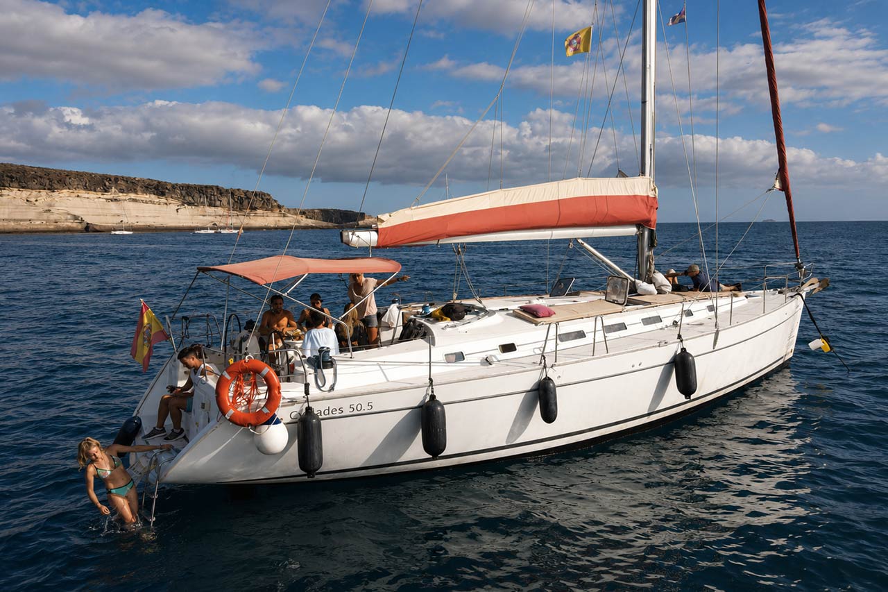 A sailing yacht anchored off Tenerife with guests swimming
