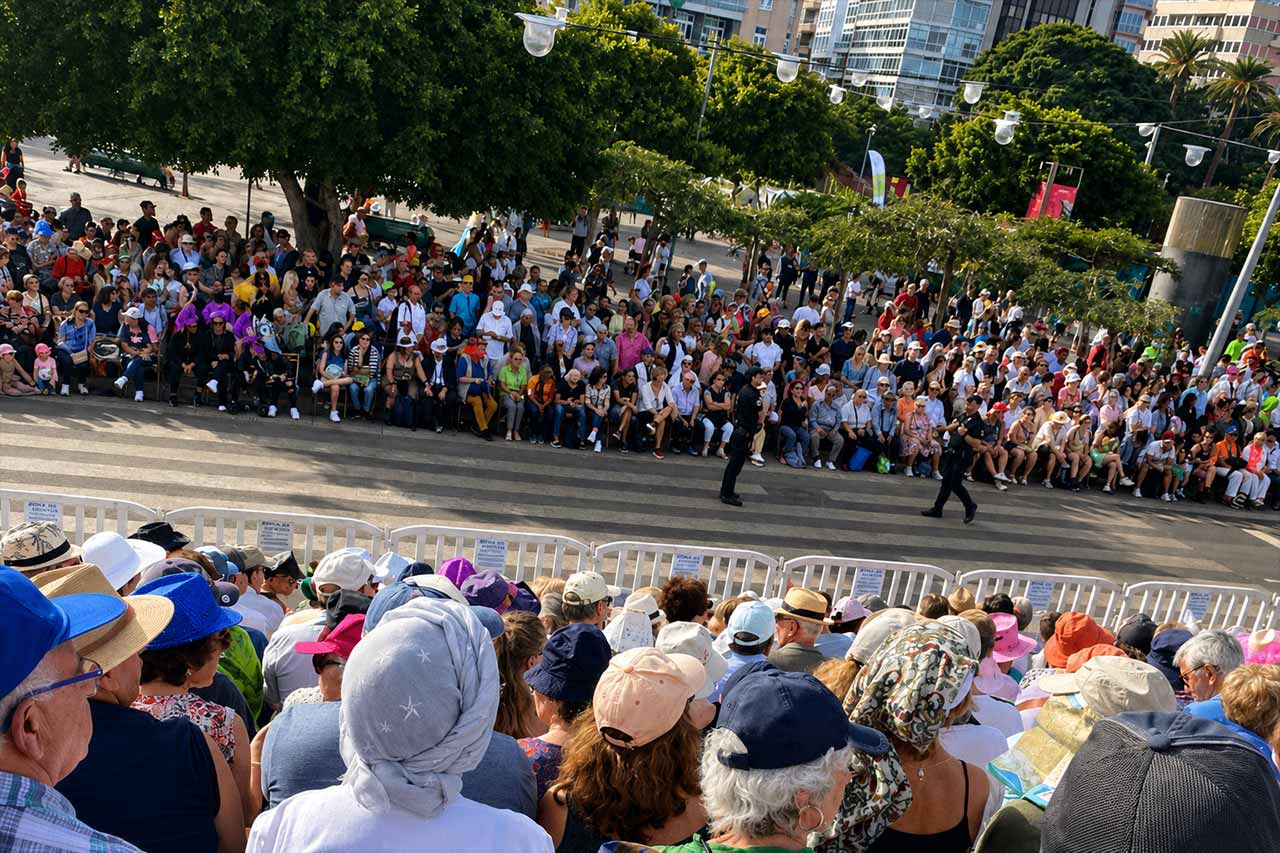 Los espectadores llenan la zona de asientos reservados durante el desfile del Carnaval de Santa Cruz de Tenerife. Las gradas elevadas ofrecen una vista despejada de todo el recorrido del desfile, mientras grandes multitudes se reúnen en el lado opuesto de la calle para ver pasar a los artistas y grupos del carnaval por la ciudad
