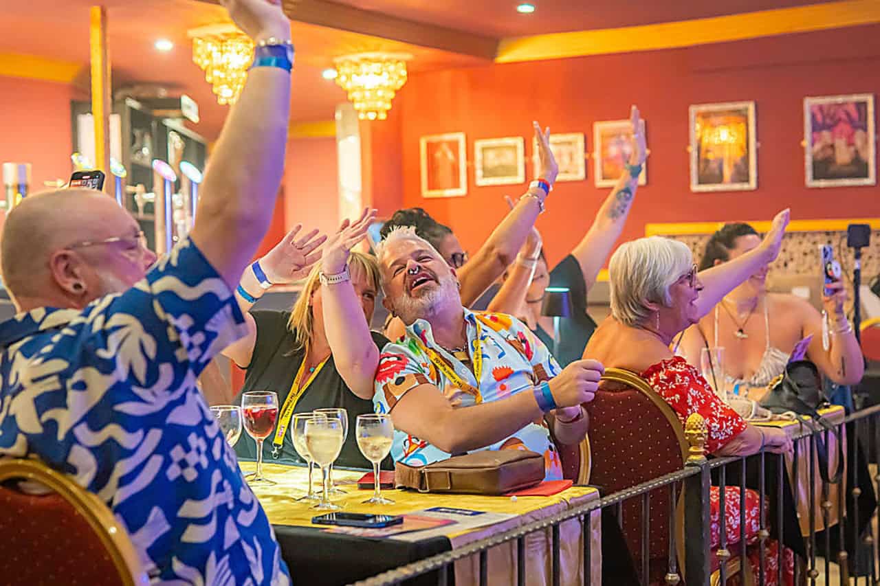 Guests laughing and raising their hands during the MHT comedy show