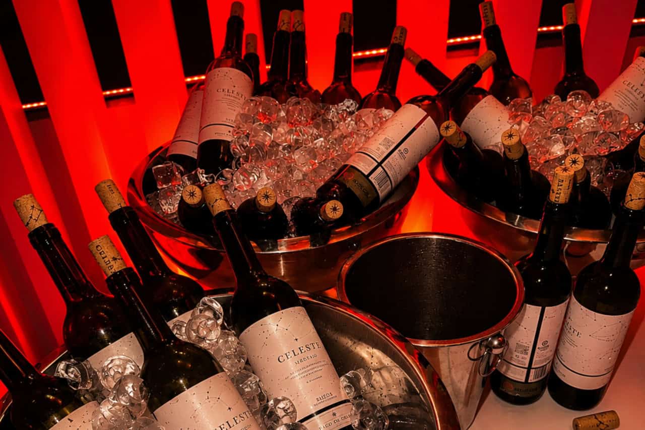 Bottles of wine chilled on ice under red lighting at the Scandal Dinner Show Tenerife.