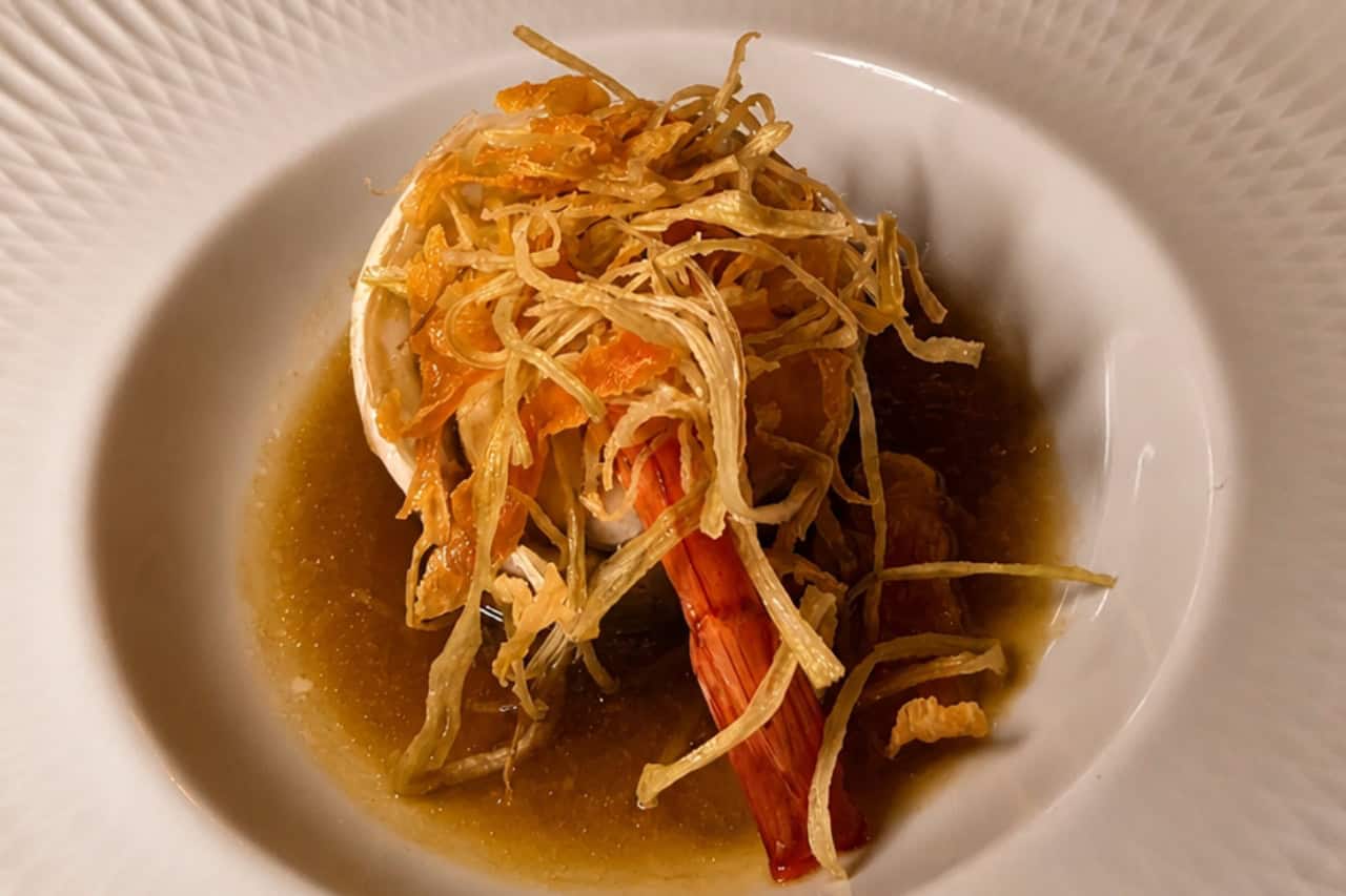 Example of a plated prawn course with sauce and crisp garnish at a tasting menu dinner show Tenerife.