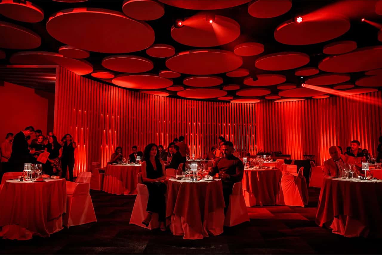 Elegant dinner tables and red lighting inside the Scandal Dinner Show venue