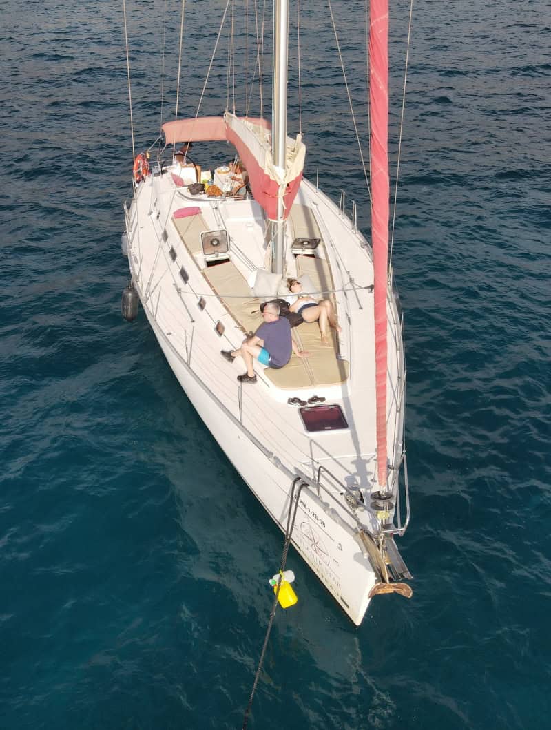 Aerial view of a couple relaxing on the sun cushions of a private sailing boat in Tenerife near Costa Adeje