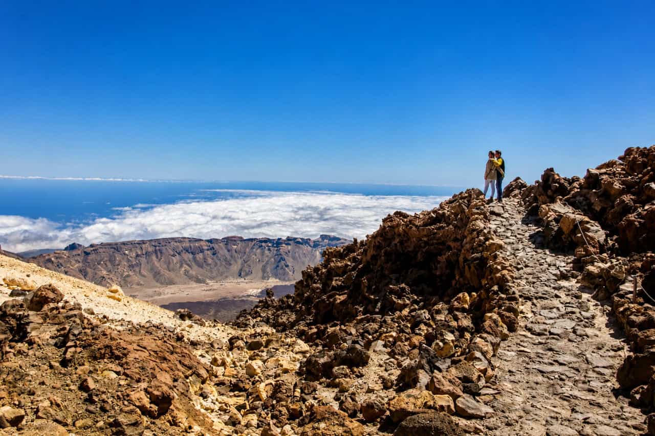 Mountain hiking trail above the clouds with panoramic views during the Official Teide Hike in Tenerife.
