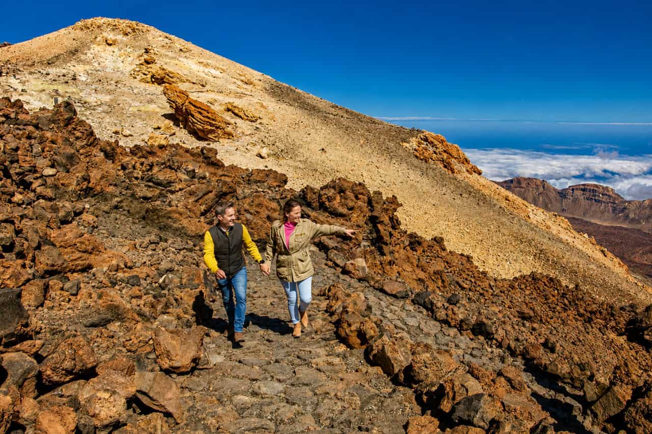 Couple hiking through the volcanic landscape of Mount Teide during the Official Teide Hike in Tenerife.