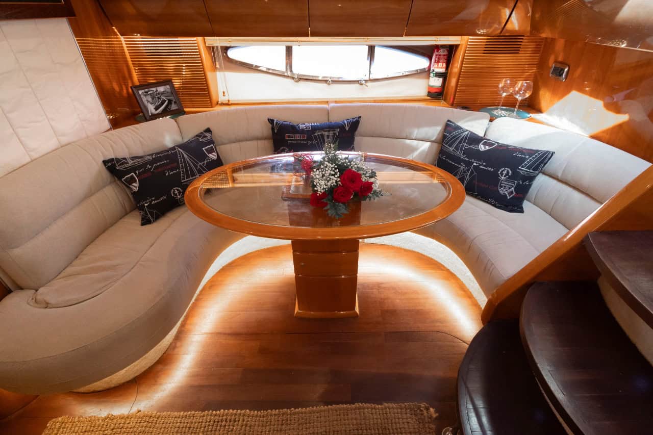 Indoor dining and seating area inside a luxury Los Gigantes yacht charter with elegant finish