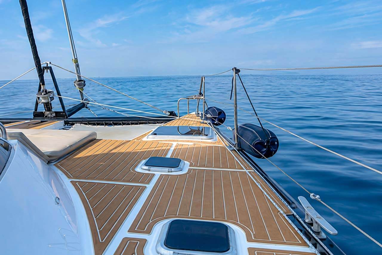 Ruim teakhouten dek en boeggedeelte aan boord van de Abrazo met een onbelemmerd uitzicht over de Atlantische Oceaan op Tenerife