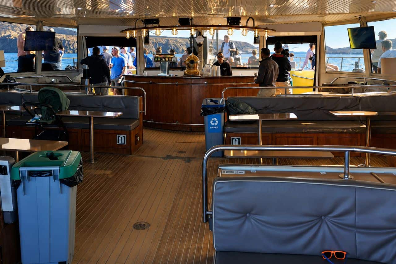 Spacious indoor lounge and bar aboard Freebird Gold, providing a comfortable setting for executive groups, company events and premium corporate boat charters in Tenerife.