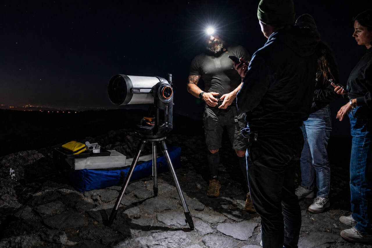 Guía de astronomía explicando el telescopio al grupo