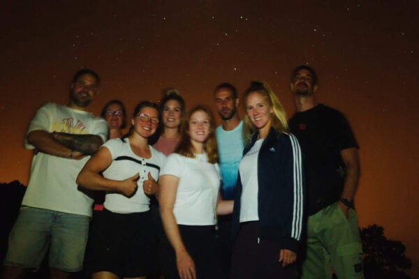 Petit groupe d'amis profitant du ciel nocturne lors d'une excursion Mount Teide d'observation des étoiles avec télescopes.