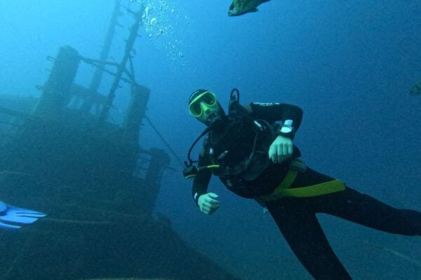 Naras, tyrinėjantis povandeninį laužą Tenerifėje per PADI atviro vandens kursus skaidriame Atlanto vandenyje.