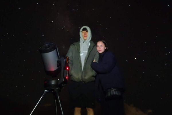 Couple debout à côté d'un télescope sous les étoiles lors d'une expérience d'observation des étoiles Mount Teide.