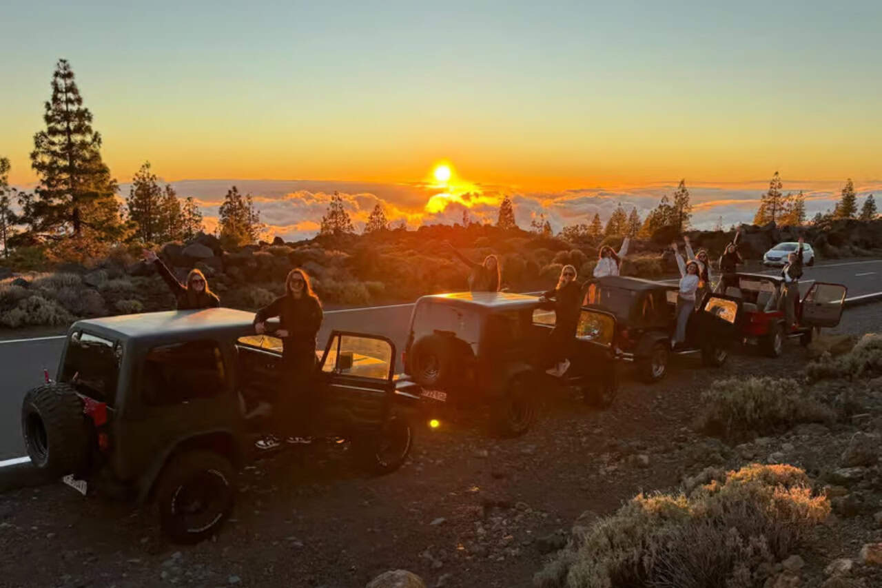 Jeeps parked on a view point over the clouds