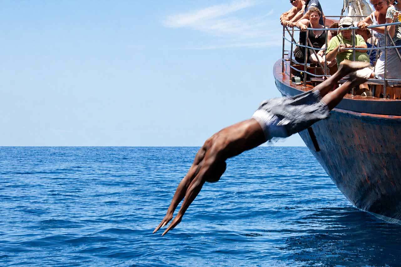 Een gast die vanaf de Shogun in de Atlantische Oceaan duikt tijdens de zwemstop in Tenerife.