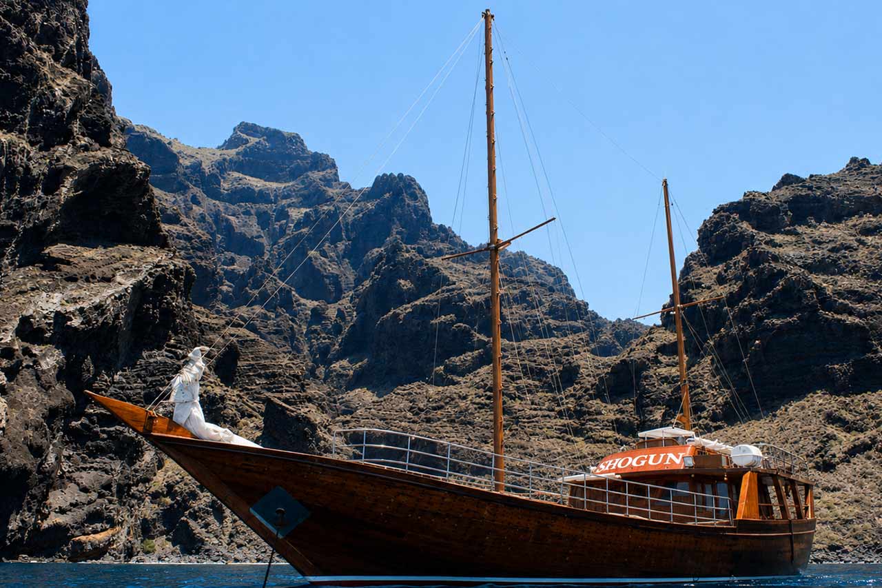 Shogun geframed door de dramatische vulkanische kliffen van Los Gigantes tijdens haar zeilroute op Tenerife