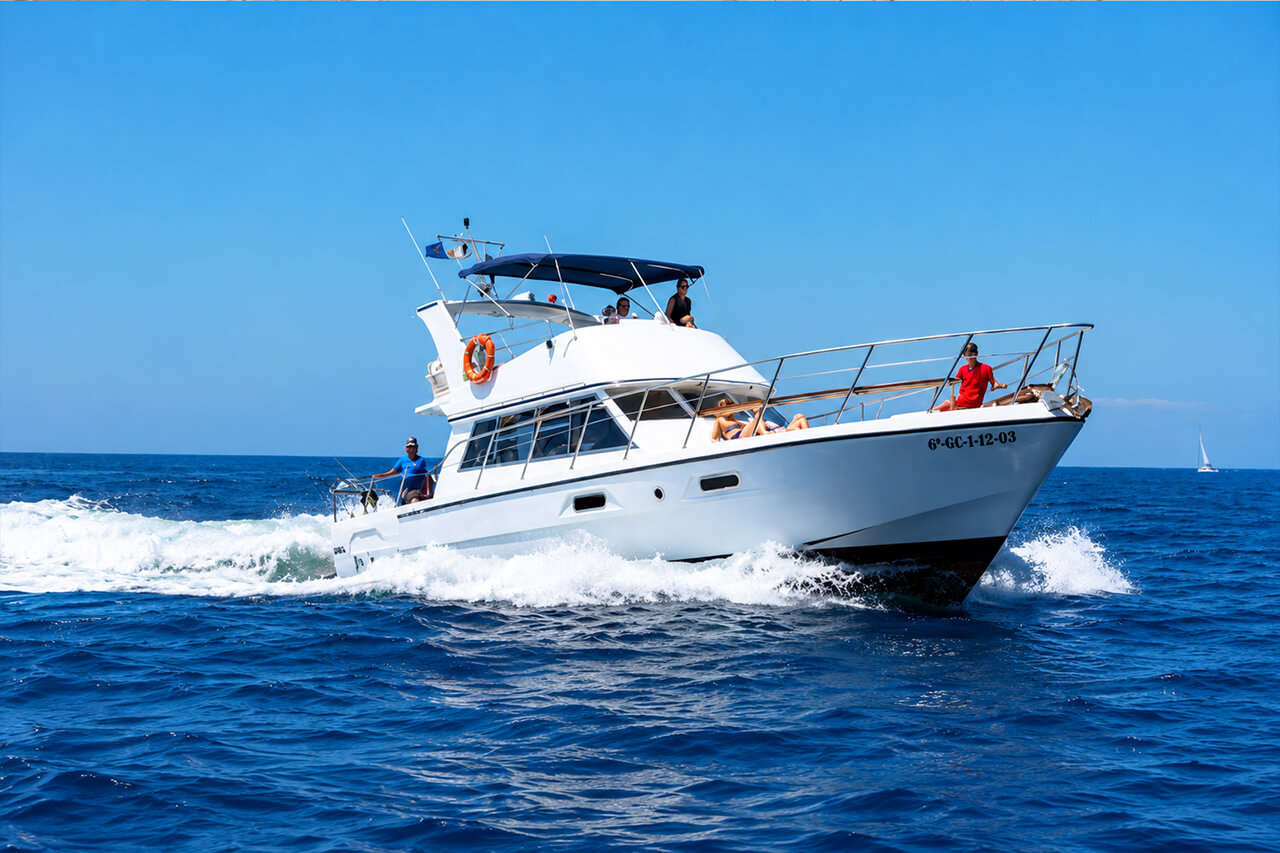 The white Neptuno motor yacht cruising across the Atlantic Ocean in Tenerife, with guests relaxing on deck and enjoying the sunshine and sea views.