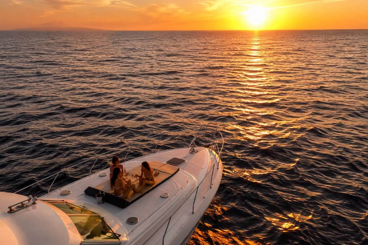 Proa del yate Valkyrie frente a una puesta de sol dorada en el Atlántico