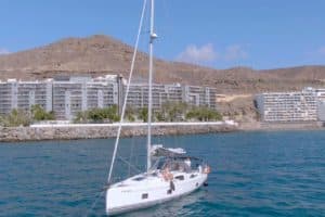 Blue Dream Segelyacht auf dem Meer mit Gebäuden und einem Berg im Hintergrund