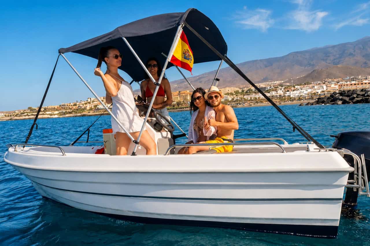 Vrienden die met hun eigen boot langs de kust van Costa Adeje varen