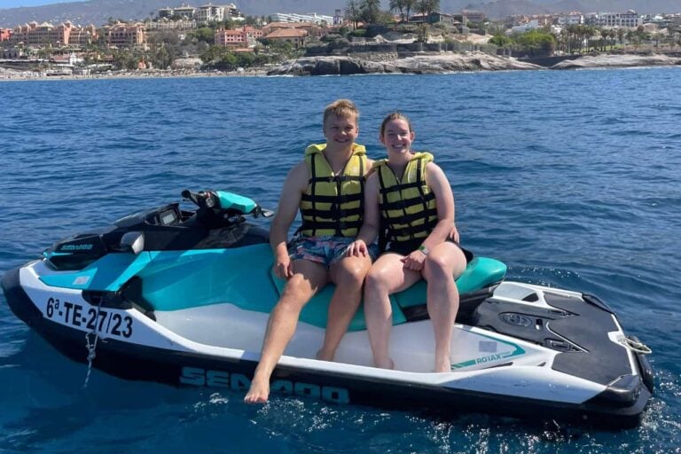 Cuplu zâmbitor așezat pe un jet ski Seadoo în timpul turului Costa Adeje Tenerife