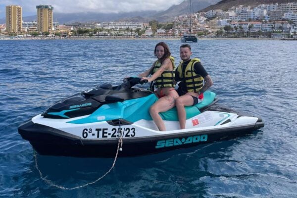 Laimīgs pāris uz ūdens motocikla Puerto Colon Tenerifes jahtu ostā
