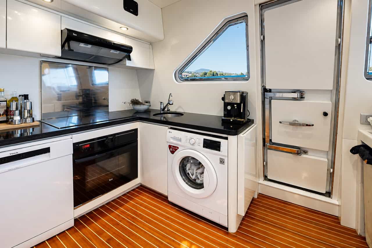 Modern yacht kitchen with oven, coffee machine and other facilities for a crewed yacht holiday in the Canary Islands.