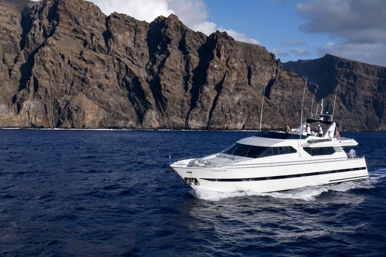 Rockstar luxury yacht charter in Tenerife cruising beside the dramatic Los Gigantes cliffs during a private VIP boat experience.