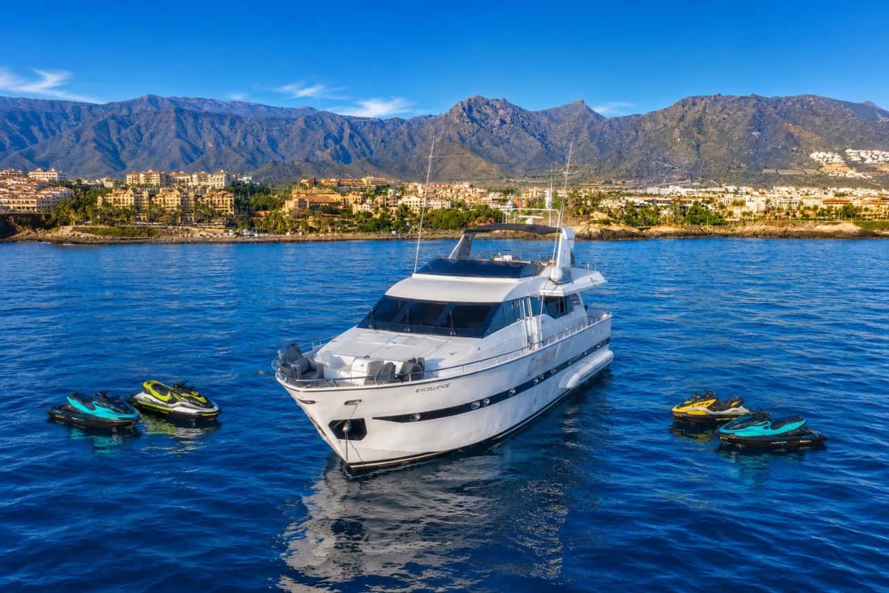Luxury Rockstar yacht charter in Tenerife surrounded by jet skis off the south Tenerife coast, showcasing a private VIP yacht experience with water sports.