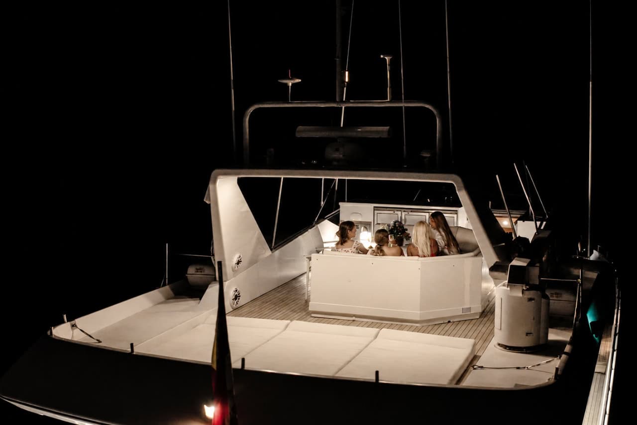 Private evening gathering aboard the Rockstar yacht in Tenerife, showing the illuminated outdoor lounge used for luxury dinners and special occasions.