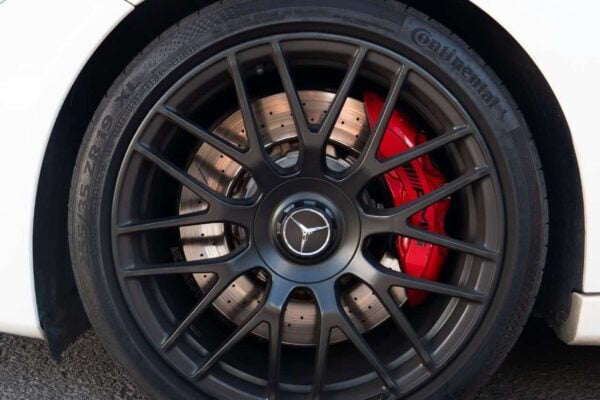 Крупный план черного легкосплавного диска Mercedes C63S AMG с красными тормозными суппортами AMG Performance на Тенерифе.