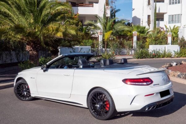 Mercedes C63S AMG cabriolet в Тенерифе показан с заднего ракурса с опущенной крышей и черными легкосплавными дисками.