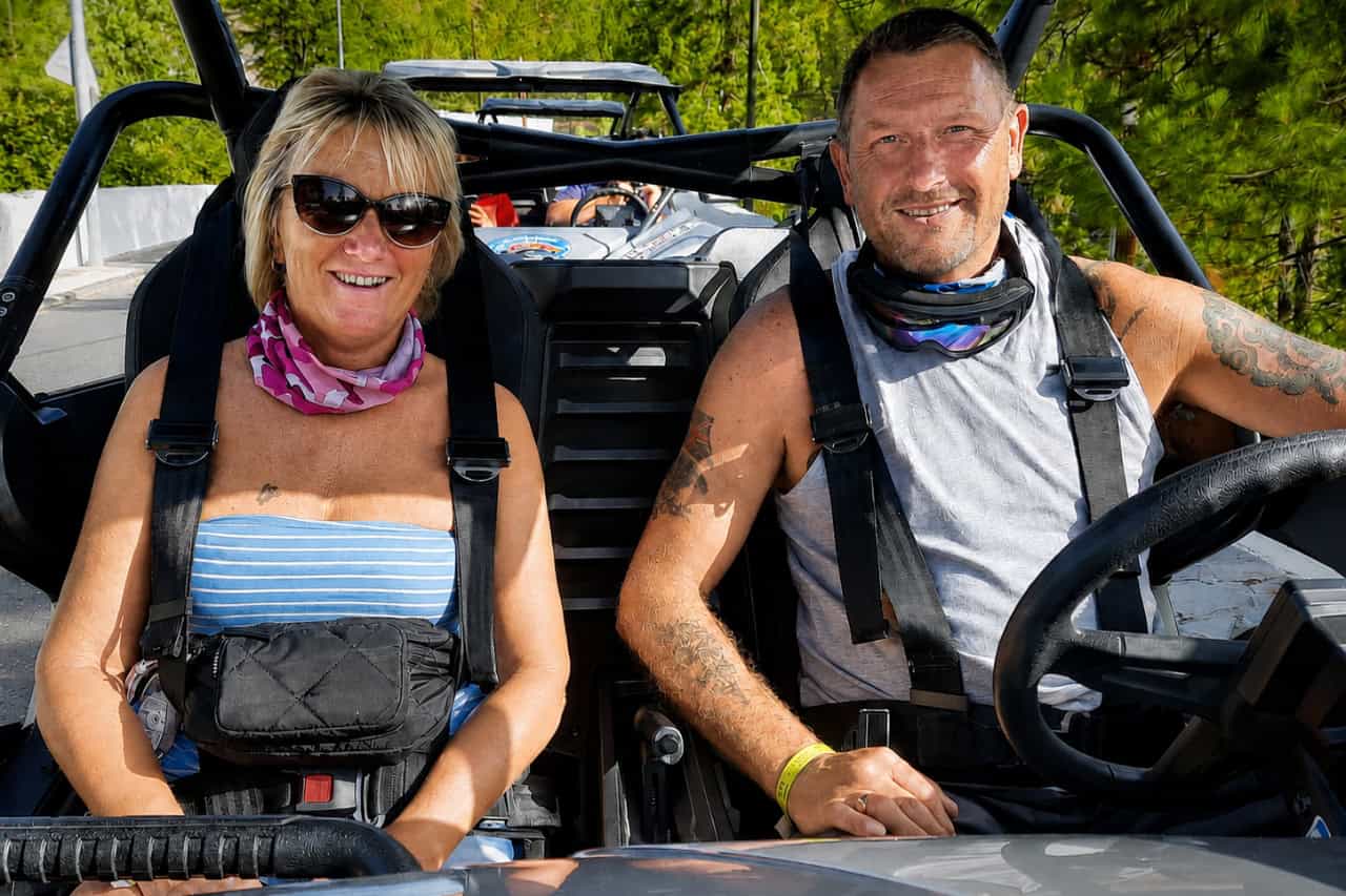 Two smiling riders seated and secured inside an off-road buggy during a Tenerife adventure tour.