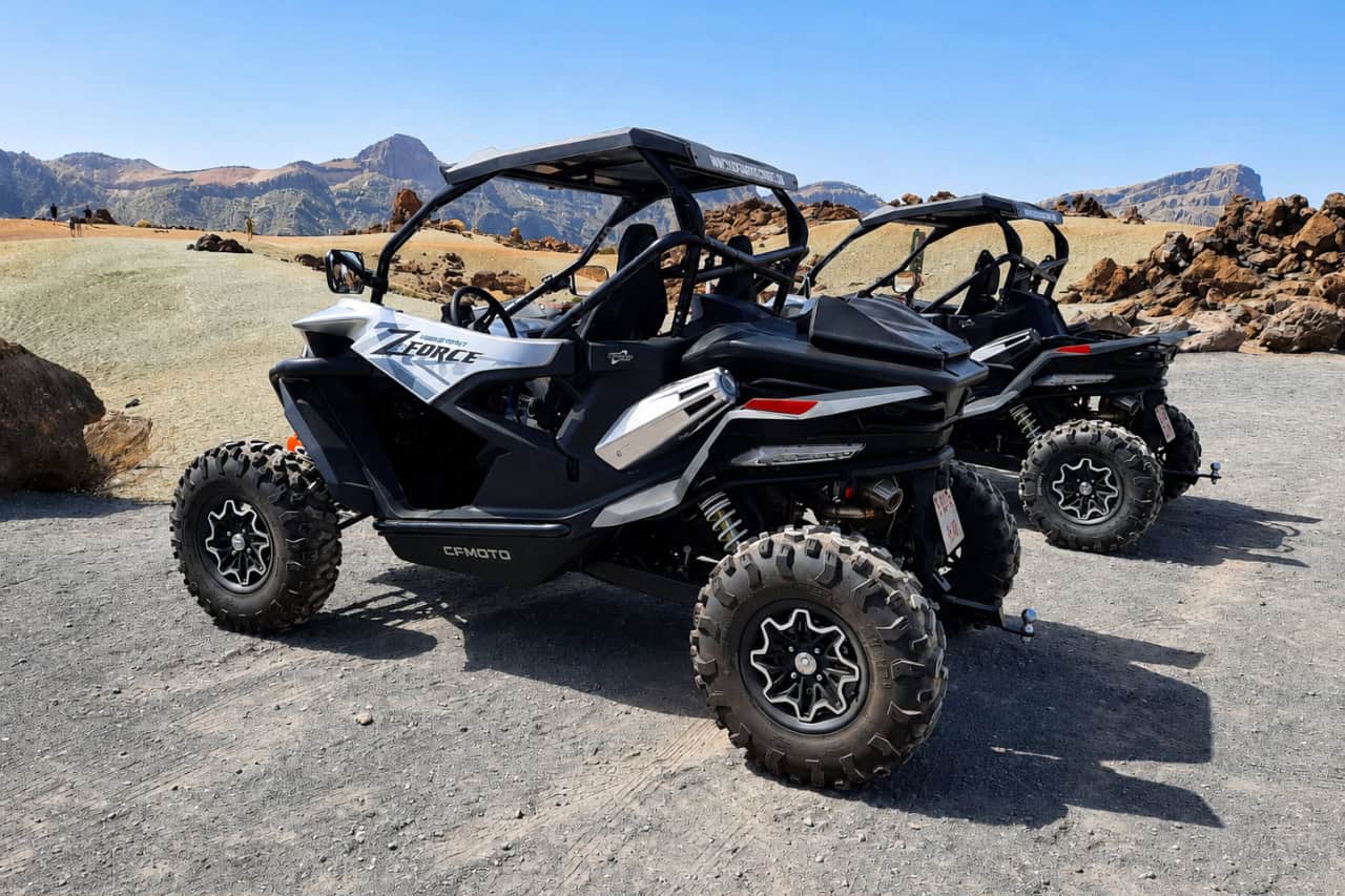 Two off-road buggies parked in the rugged volcanic landscape of Teide National Park.