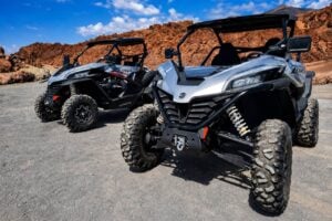 Two CFMOTO ZForce buggies parked among the volcanic rock formations of Tenerife.
