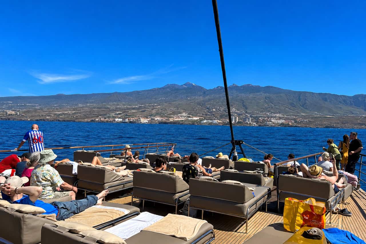 Gasten die ontspannen op het ruime dek van de Freebird-catamaran tijdens een boottour inclusief hoteltransfer vanuit Puerto de la Cruz.