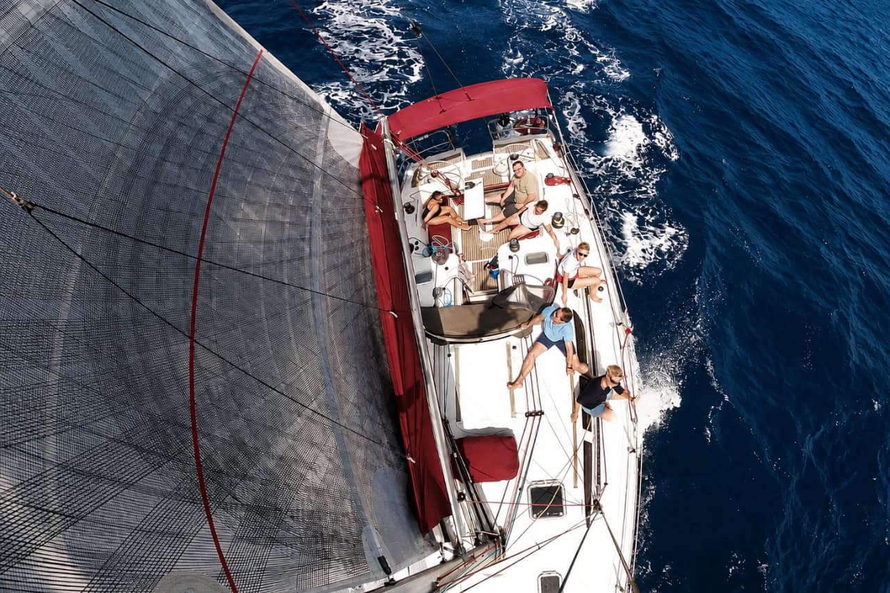 Aerial view from the mast of guests on the sailing yacht in deep blue water